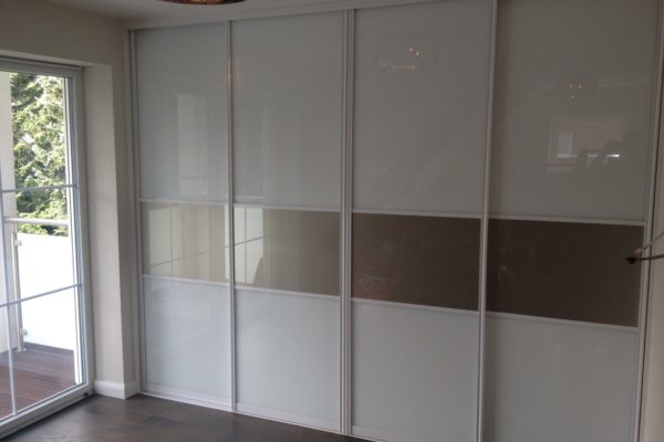 Schlafzimmer-Schrank in einer Gaube mit weißen Glas-Schiebetueren